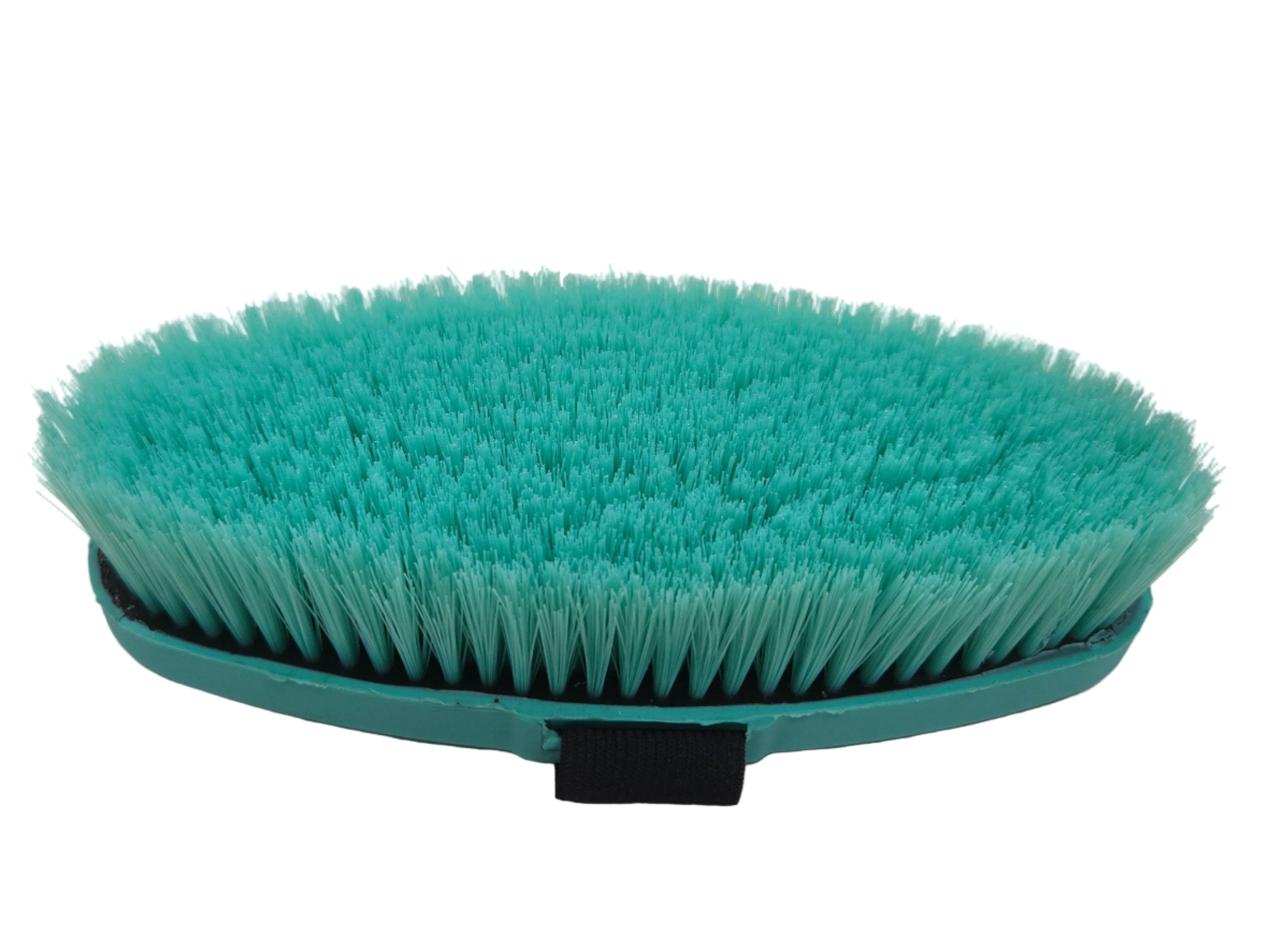 Green brush on a white surface with a blurred background