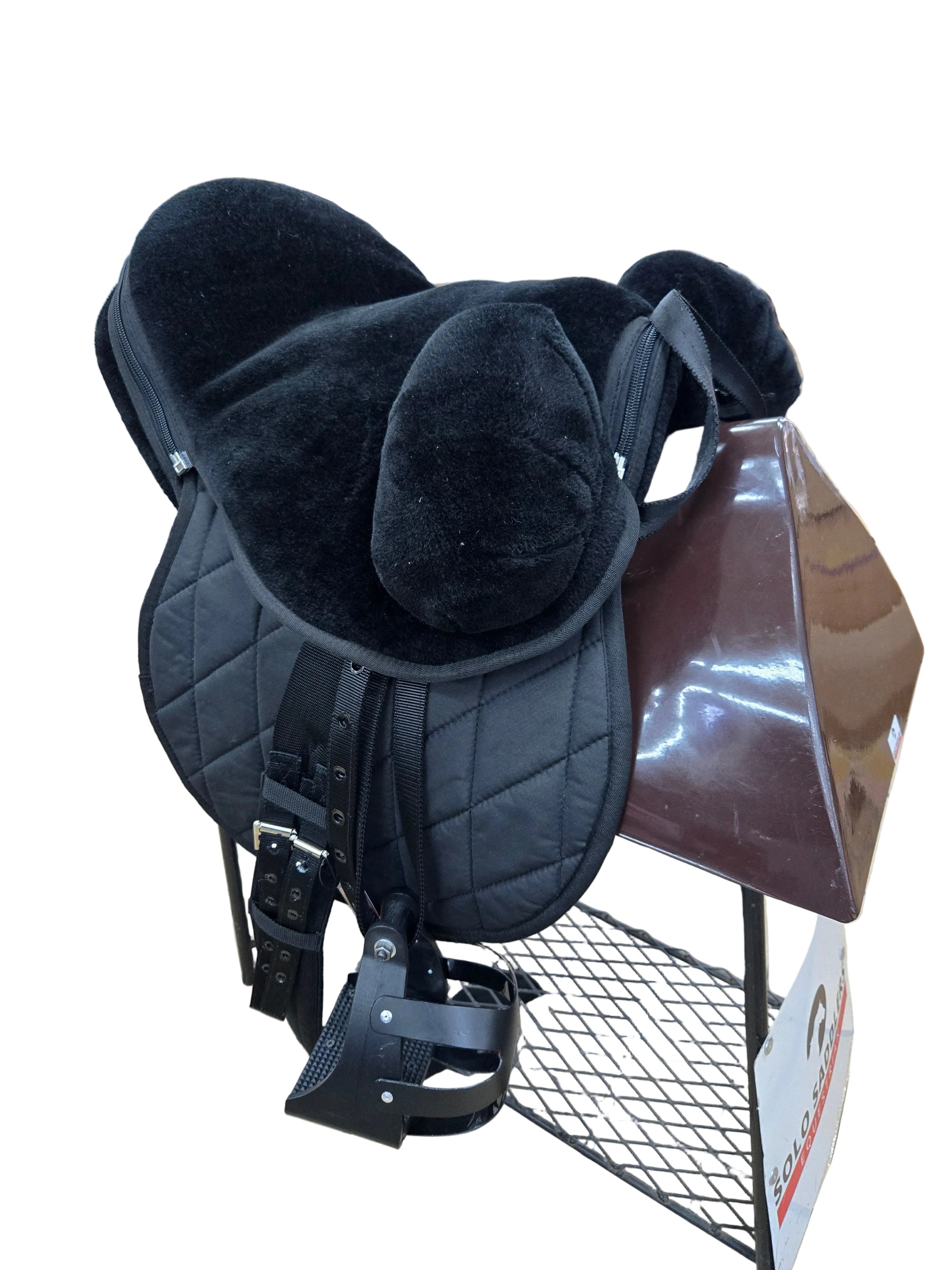 Black sheepskin saddle on a tiled floor