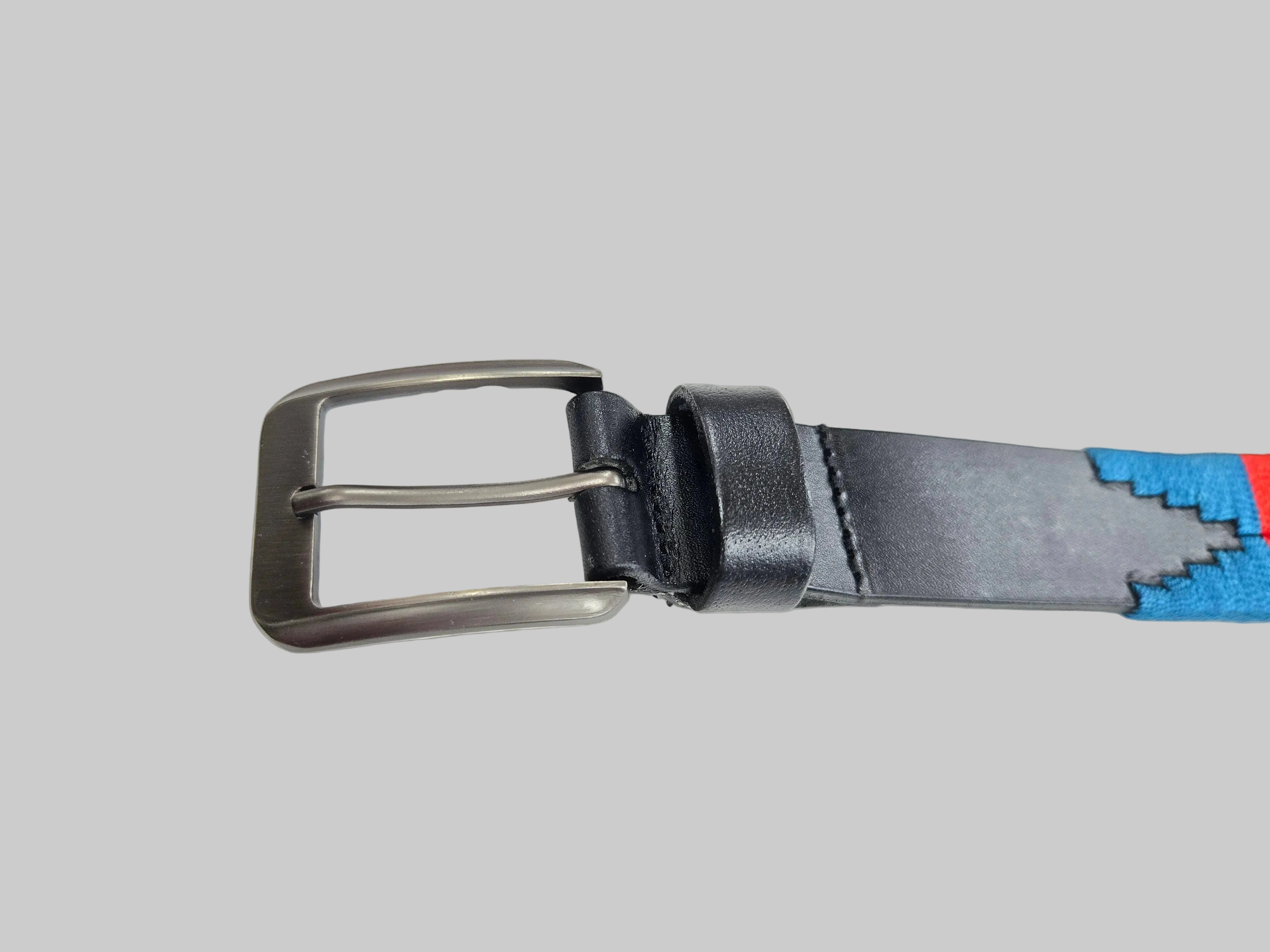 Black belt with a silver buckle on a light gray background