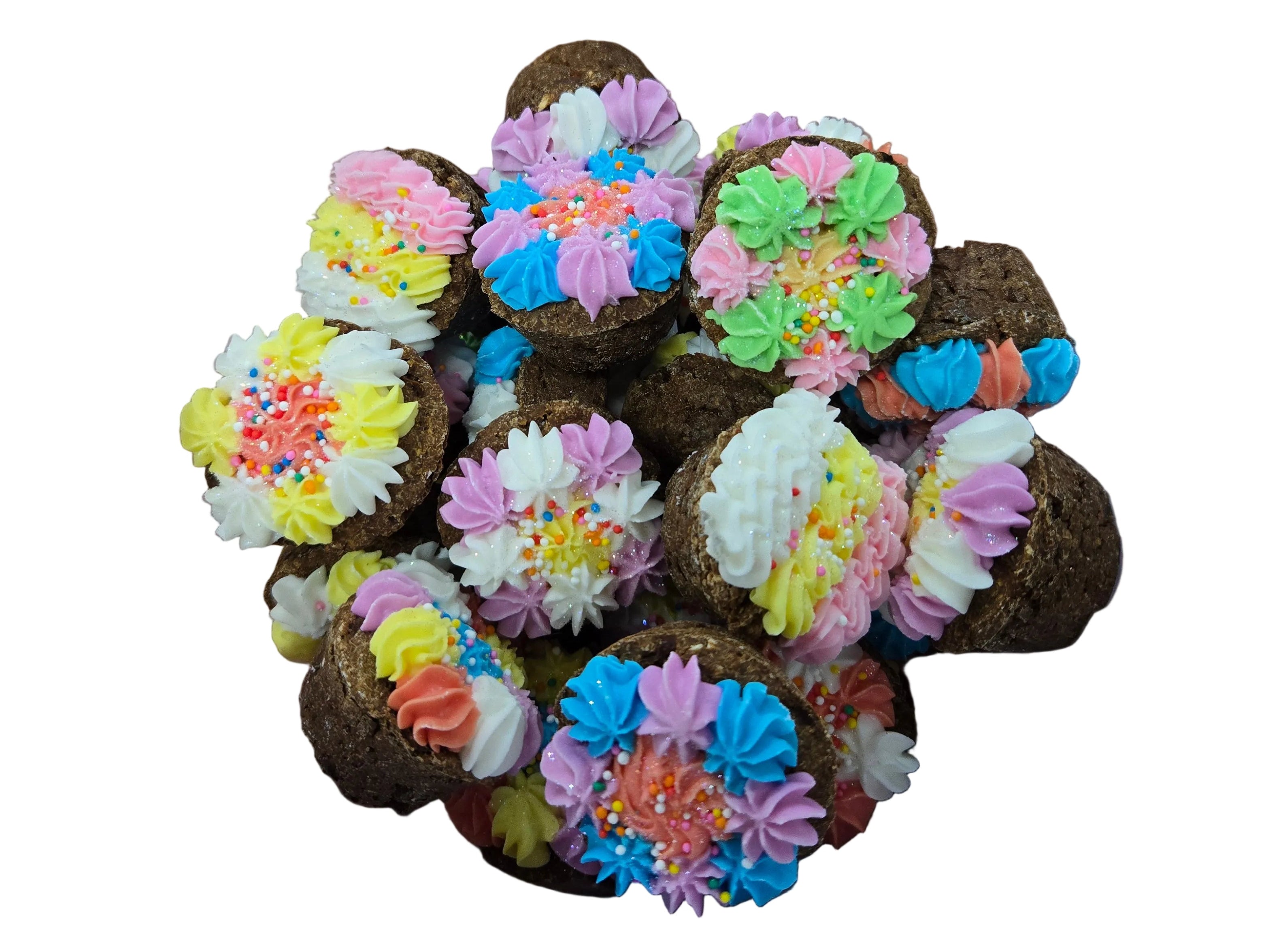 Container of small, round desserts with colorful floral decorations on a wooden desk.