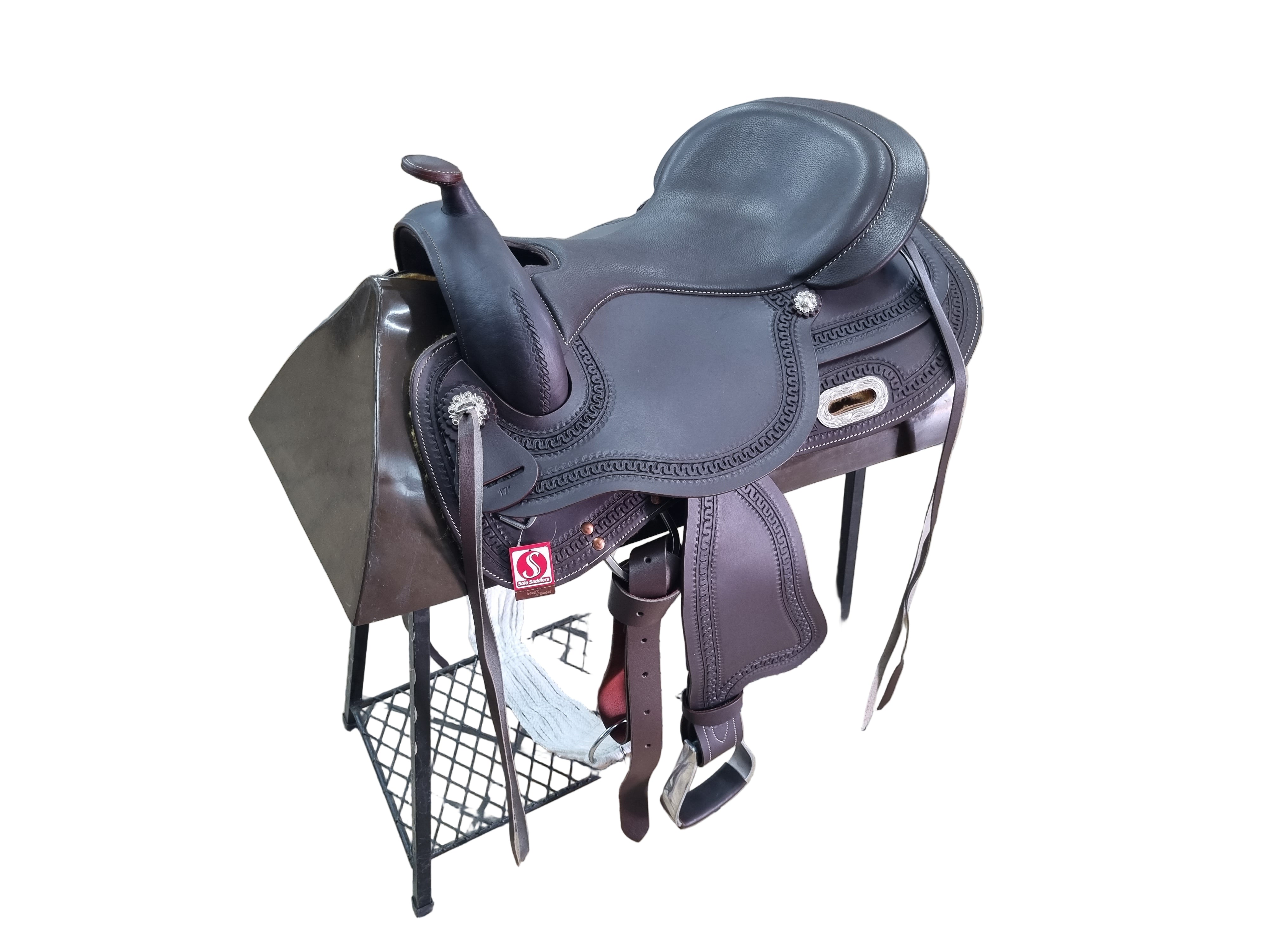 Brown leather saddle on a stand in an indoor setting with tiled floor