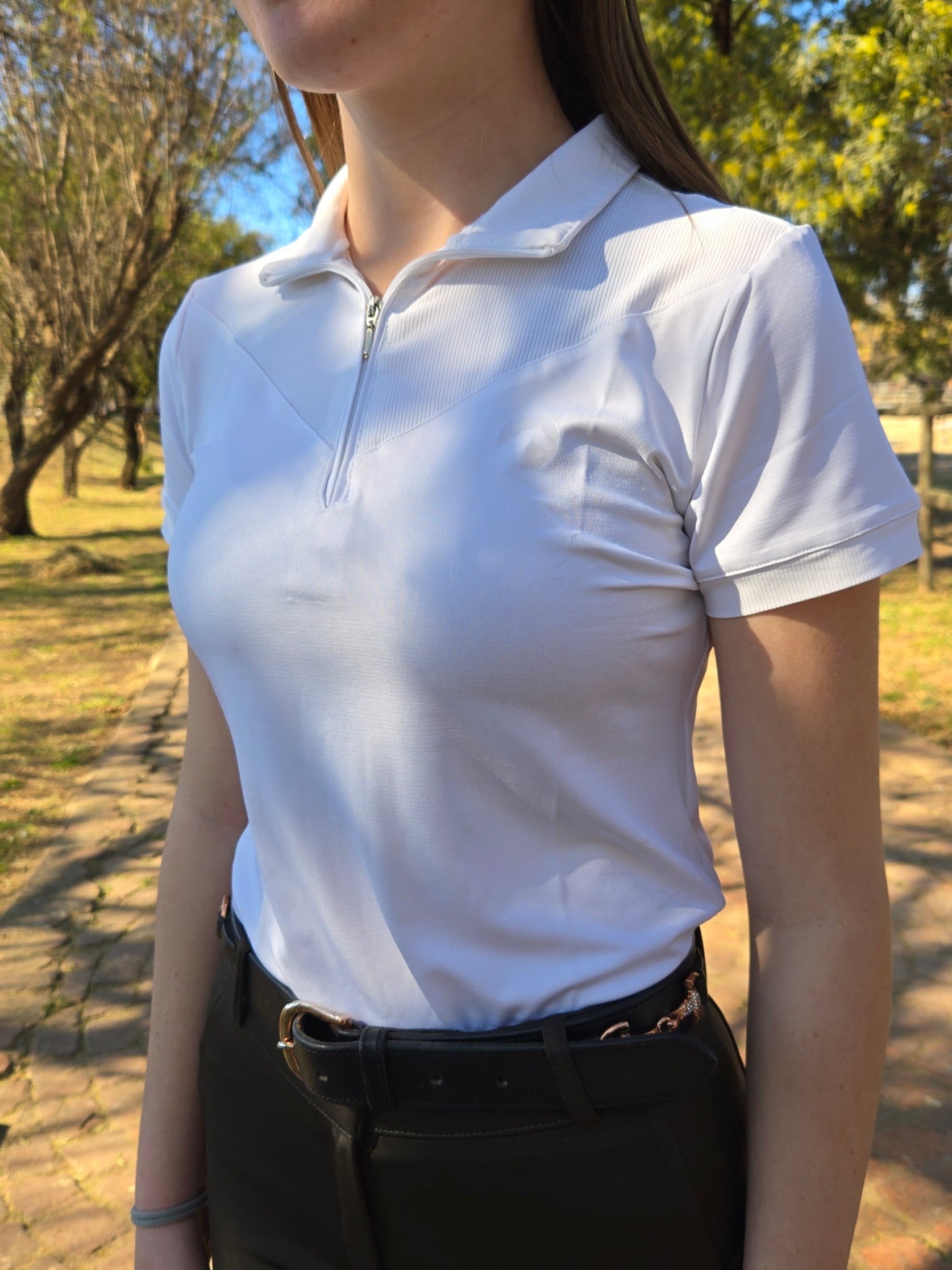 Person wearing a white top with a blurred background